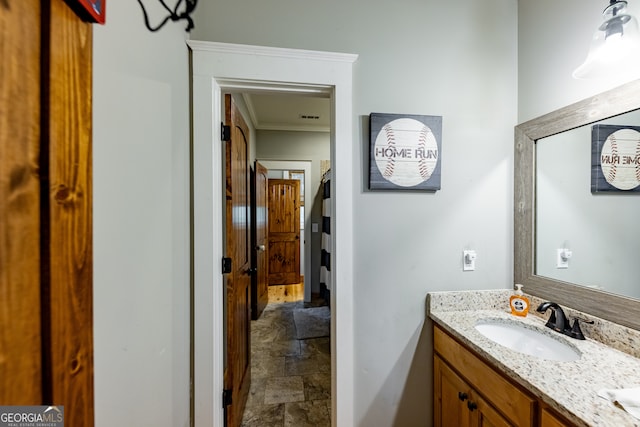 bathroom with ornamental molding and vanity