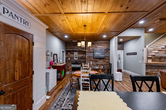 dining space featuring a chandelier, wood ceiling, wooden walls, and hardwood / wood-style flooring