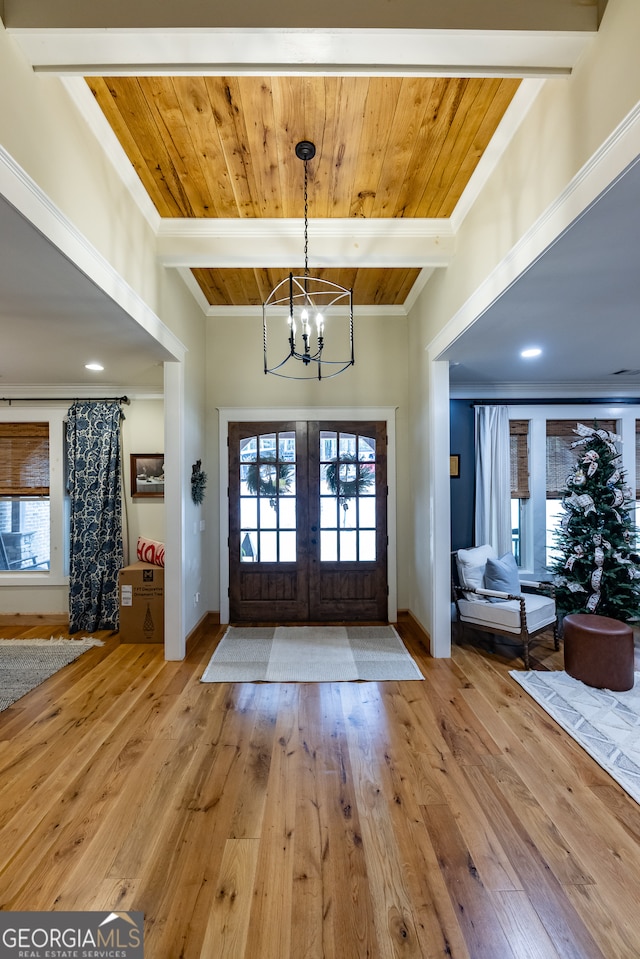 foyer with french doors, light wood-type flooring, a healthy amount of sunlight, and an inviting chandelier