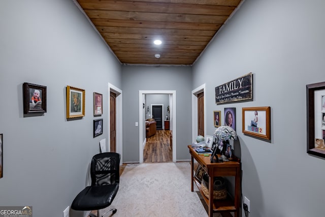 corridor featuring light carpet and wood ceiling