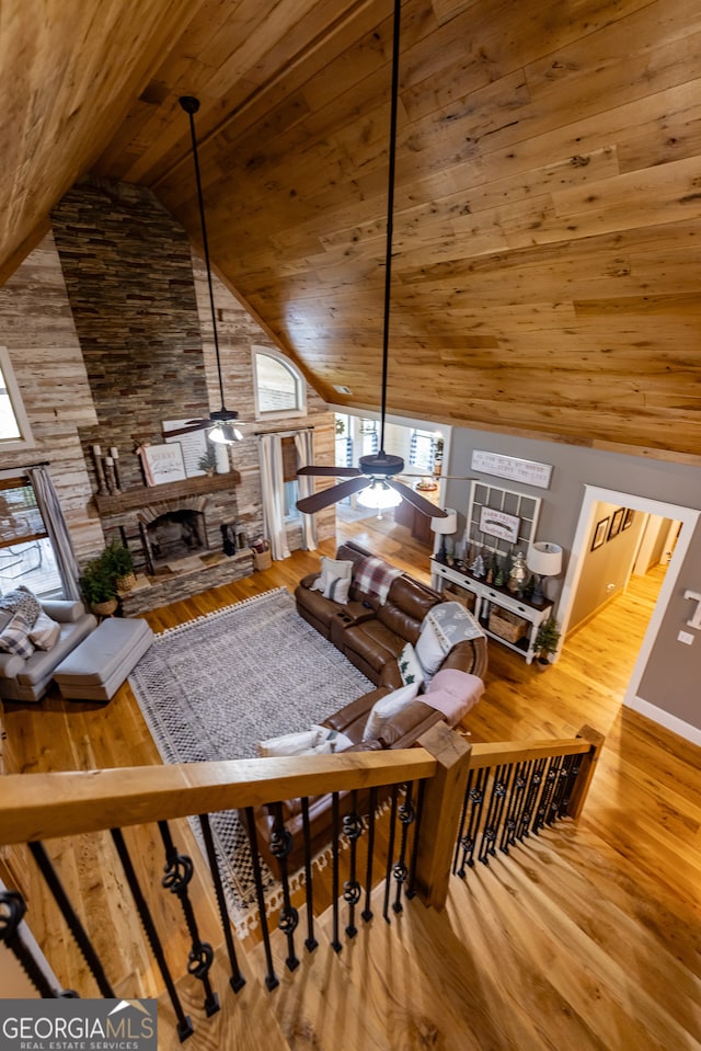 living room featuring a fireplace, high vaulted ceiling, wood ceiling, hardwood / wood-style flooring, and ceiling fan