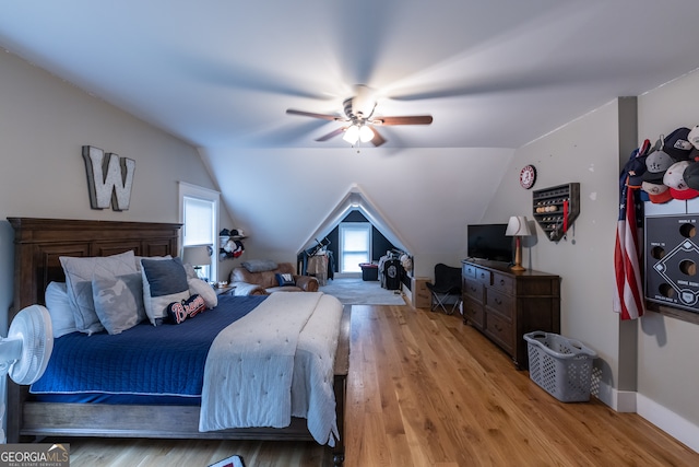 bedroom with light hardwood / wood-style flooring, lofted ceiling, and ceiling fan