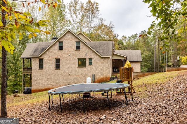 back of property featuring a trampoline