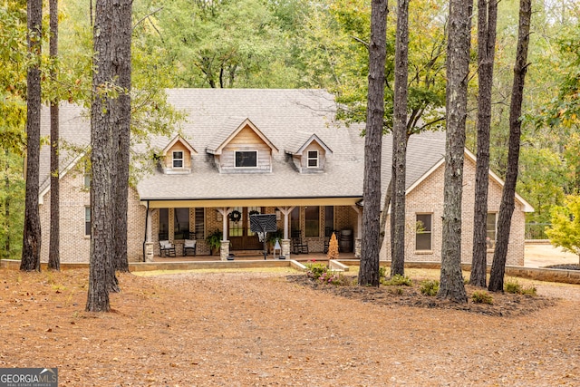 cape cod home featuring a porch