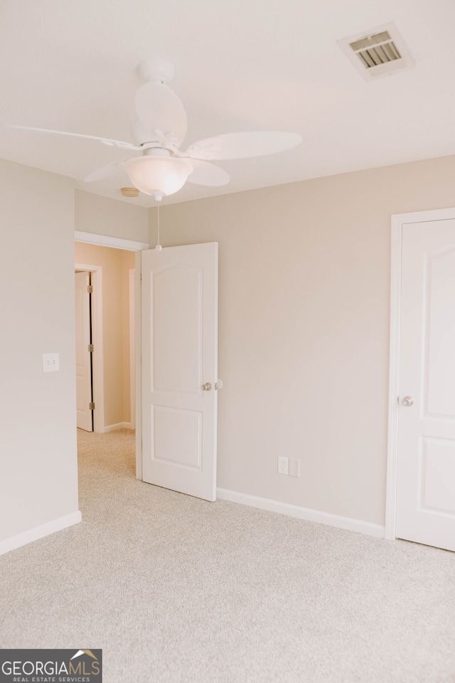 carpeted spare room with ceiling fan