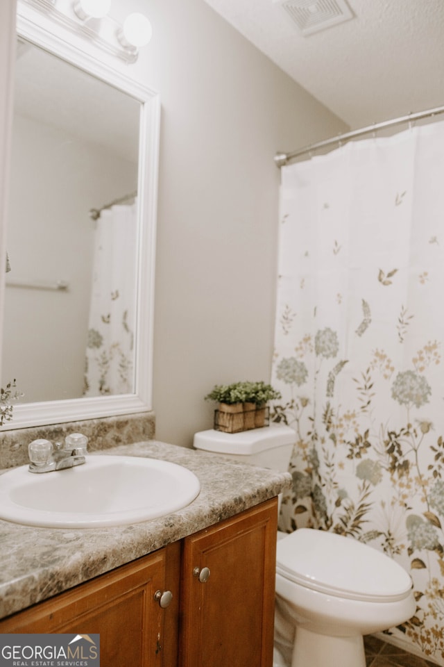 bathroom featuring toilet and vanity