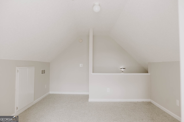 additional living space with light colored carpet and lofted ceiling