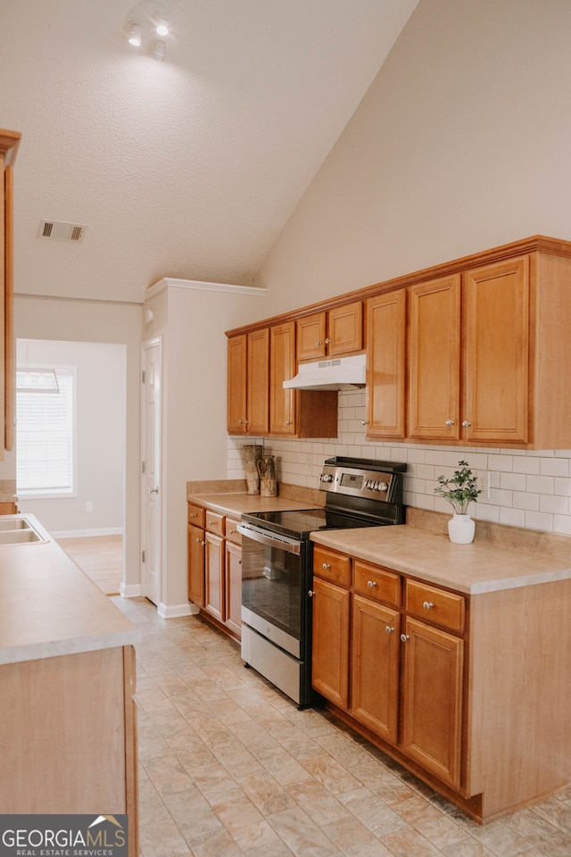 kitchen featuring light tile patterned floors, decorative backsplash, high vaulted ceiling, and electric stove