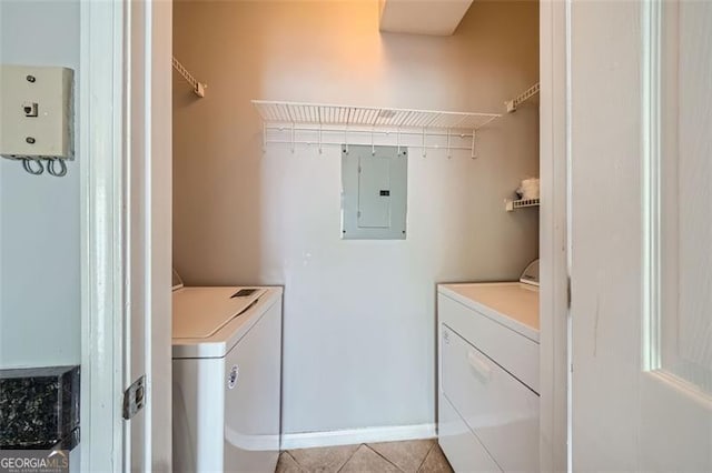 laundry room featuring washer and clothes dryer, electric panel, and light tile patterned floors