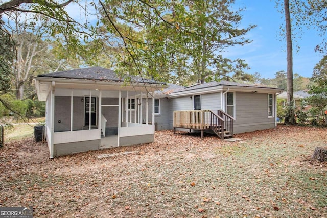 back of property with a sunroom and a wooden deck