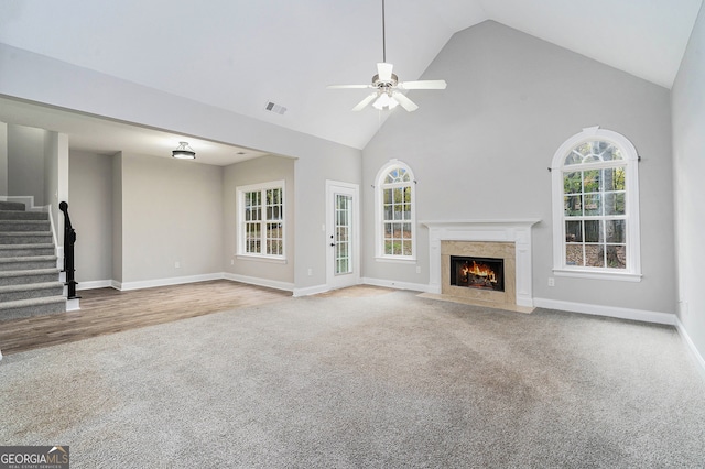 unfurnished living room with a premium fireplace, high vaulted ceiling, ceiling fan, and hardwood / wood-style floors