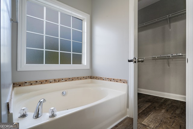 bathroom with wood-type flooring and a bathtub