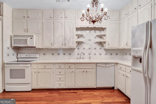 kitchen with white cabinetry, sink, white appliances, and light hardwood / wood-style floors