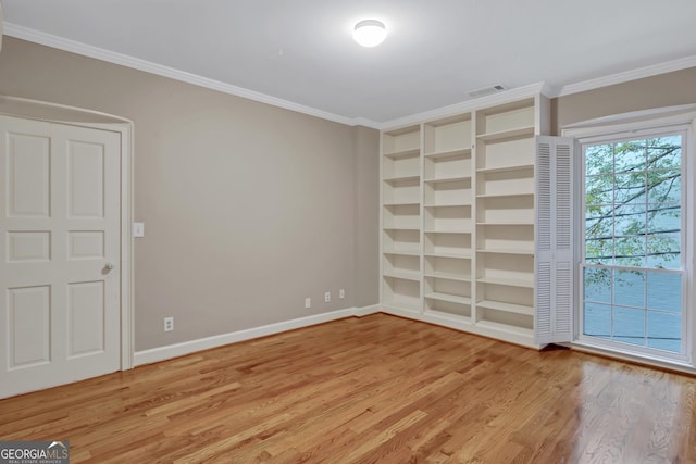 unfurnished room with crown molding, hardwood / wood-style floors, and built in shelves