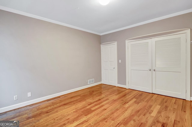 unfurnished bedroom with ornamental molding, a closet, and light hardwood / wood-style flooring