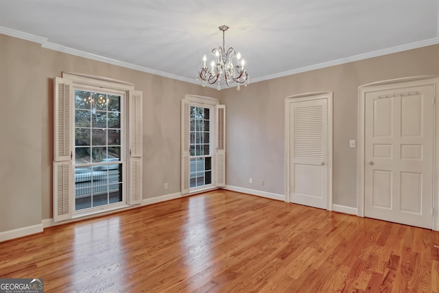 unfurnished dining area with an inviting chandelier, crown molding, and light hardwood / wood-style flooring