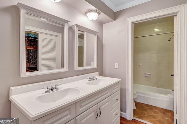 full bathroom featuring tile patterned floors, toilet, crown molding, tiled shower / bath, and vanity