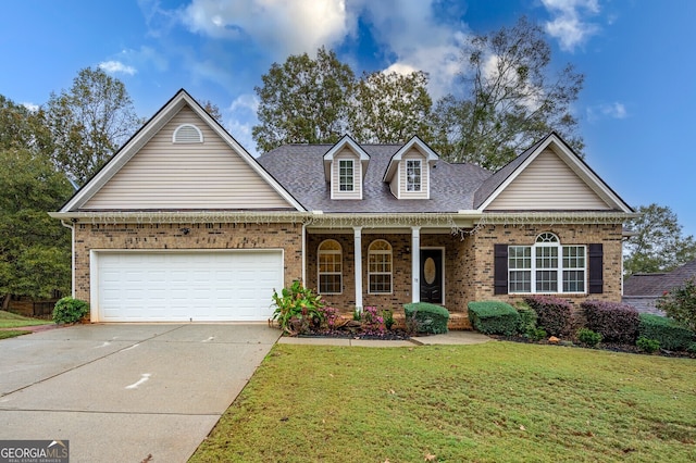 view of front of home with a garage, covered porch, and a front yard