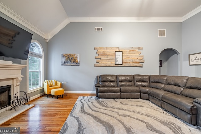 living room featuring crown molding, vaulted ceiling, and hardwood / wood-style flooring