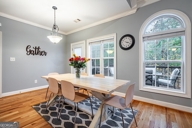 dining area featuring light hardwood / wood-style flooring, a healthy amount of sunlight, and crown molding