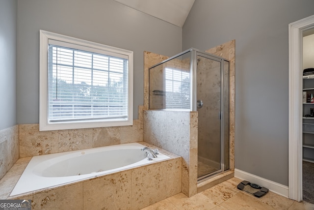 bathroom with tile patterned flooring, vaulted ceiling, and shower with separate bathtub