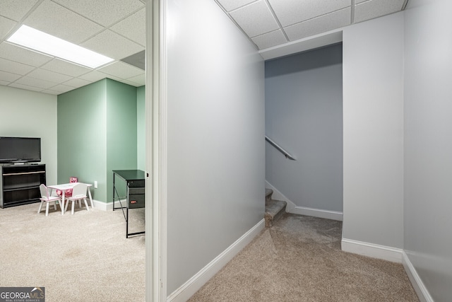 interior space with a drop ceiling and light colored carpet