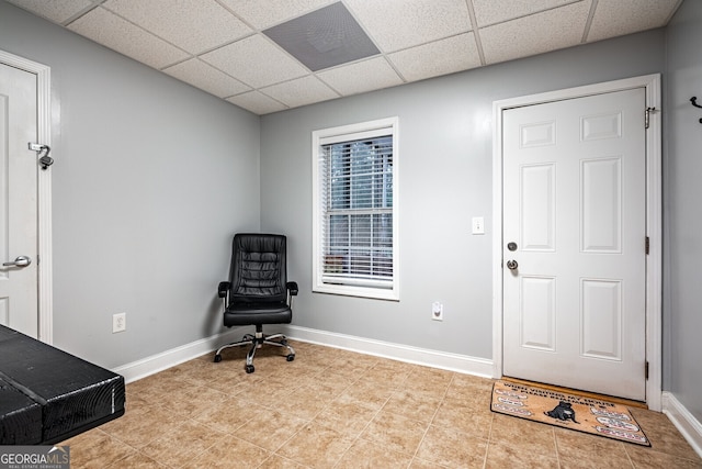 interior space featuring a paneled ceiling and light tile patterned flooring