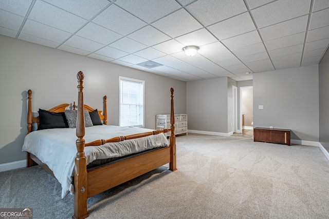 bedroom with a drop ceiling and carpet floors