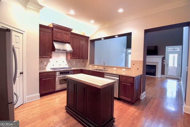 kitchen with stainless steel appliances, crown molding, sink, light hardwood / wood-style flooring, and butcher block counters