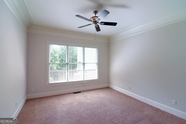 unfurnished room with plenty of natural light, light colored carpet, and ornamental molding