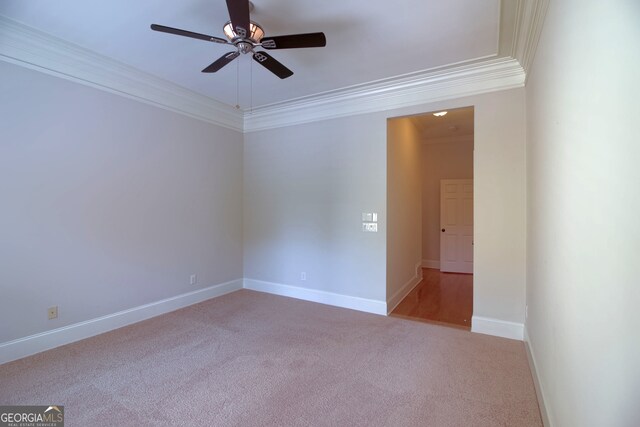 carpeted spare room featuring ceiling fan and ornamental molding