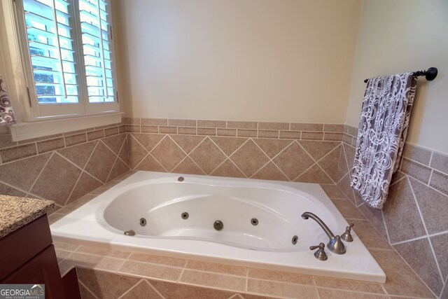 bathroom with vanity and tiled bath