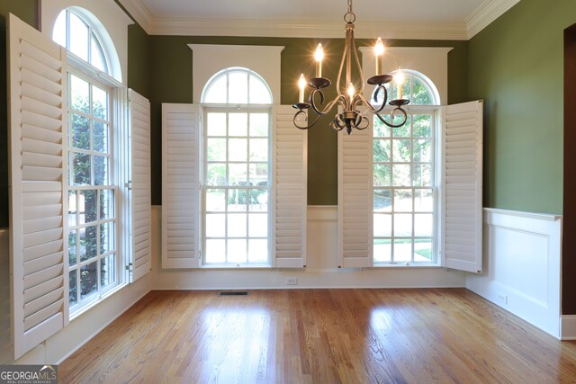 unfurnished dining area featuring a notable chandelier, a healthy amount of sunlight, and light hardwood / wood-style flooring