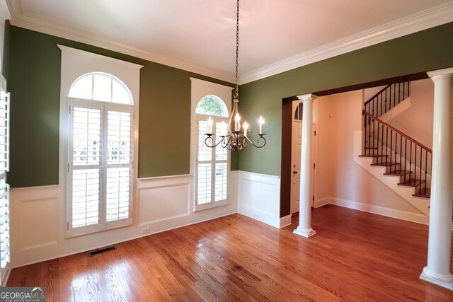 unfurnished dining area with wood-type flooring, a wealth of natural light, and ornamental molding