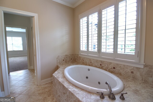 bathroom featuring tile patterned floors, tiled tub, crown molding, and a wealth of natural light