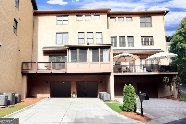 multi unit property featuring a balcony, central AC unit, and a garage