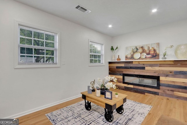 interior space with recessed lighting, a fireplace, wood finished floors, visible vents, and baseboards