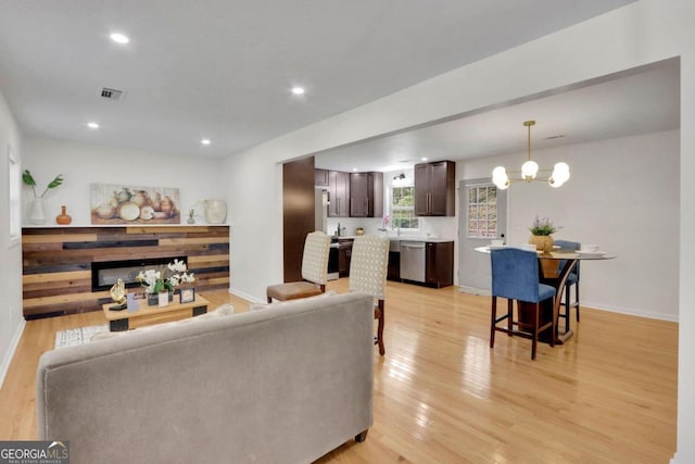 living area with a notable chandelier, recessed lighting, visible vents, light wood-style flooring, and baseboards