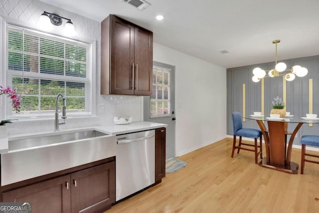 kitchen with visible vents, light wood-style flooring, a healthy amount of sunlight, stainless steel dishwasher, and a sink