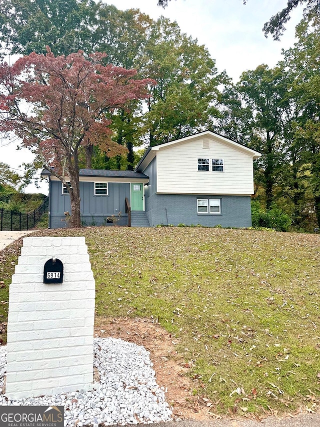 view of front of house with board and batten siding and a front lawn