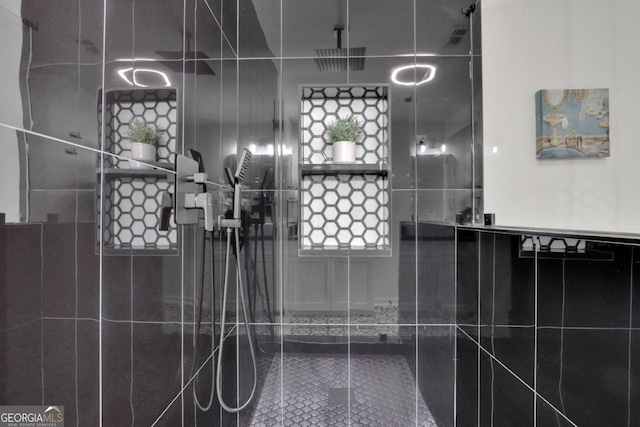 full bath featuring visible vents and a tile shower