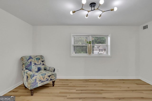 living area featuring visible vents, baseboards, and wood finished floors