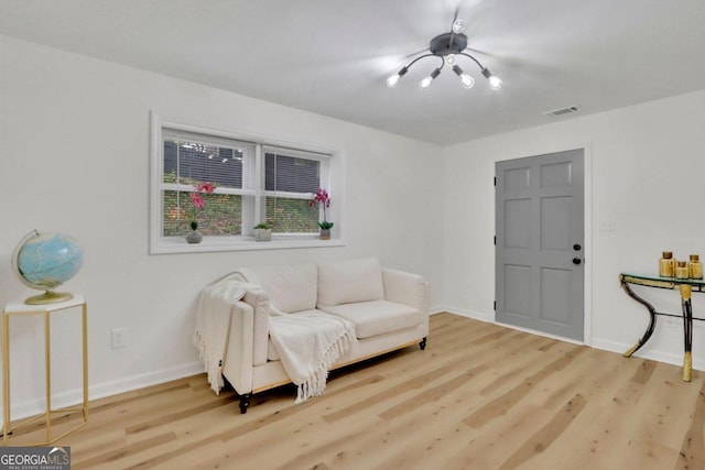 living area featuring visible vents, baseboards, and wood finished floors