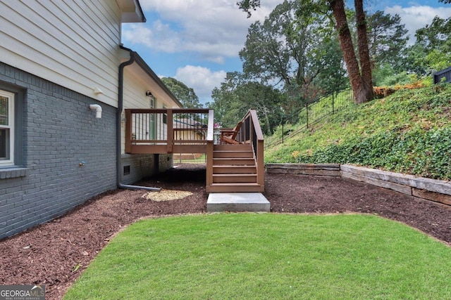 view of yard with fence, a deck, and stairs