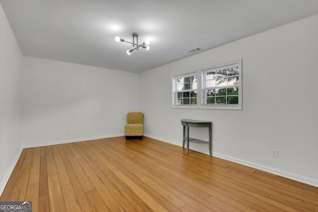 unfurnished room with light wood-style flooring, visible vents, and baseboards