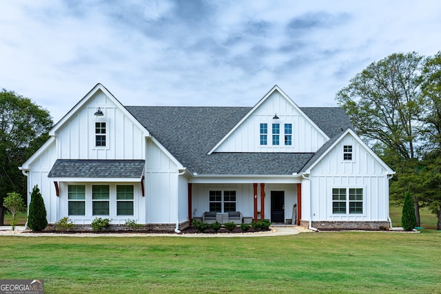 modern farmhouse style home with a front lawn and a porch