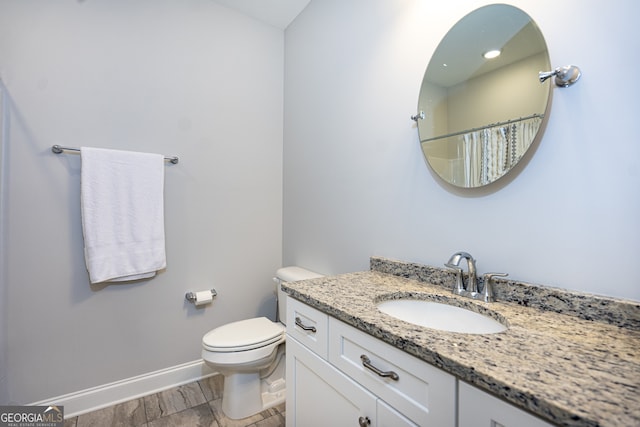 bathroom with vanity, hardwood / wood-style floors, toilet, and curtained shower