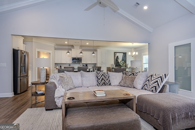 living room with ceiling fan with notable chandelier, ornamental molding, dark wood-type flooring, and high vaulted ceiling