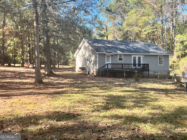 rear view of property with a yard and a deck