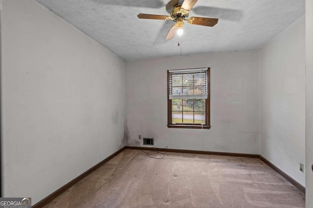 empty room featuring ceiling fan, a textured ceiling, and carpet flooring